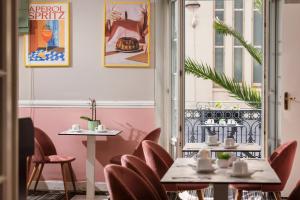 a restaurant with tables and chairs and a window at Best Western Hotel Lakmi Nice in Nice