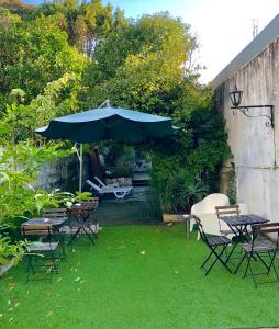 un patio con tavolo, sedie e ombrellone di GuestHouse Bragas Porto Center a Porto