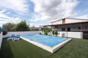 a swimming pool in a yard next to a house at Cortijo Candela in Granada