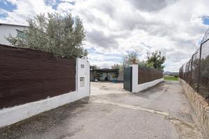 a driveway with a fence and a white garage at Cortijo Candela in Granada