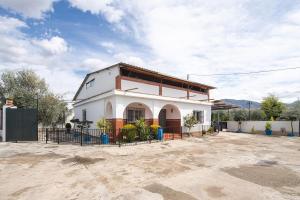 a white building with a fence in front of it at Cortijo Candela in Granada