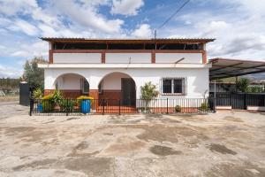 a white house with a fence in front of it at Cortijo Candela in Granada +39 photos
