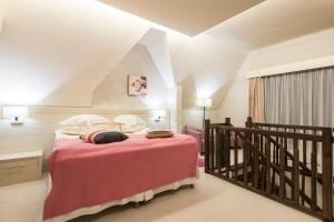 a bedroom with a bed with pink sheets and pillows at Ioana Boutique Hotel in Sinaia +200 photos