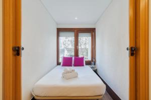 Un dormitorio con una cama con dos almohadas rosas. en Três Marias, en Tróia