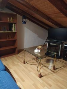 sala de estar con mesa de centro y TV en Casa Rural La Maestra, en Sigüés