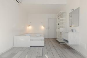 a white room with a bed and a sink at My Tiny Home in Rome +37 photos