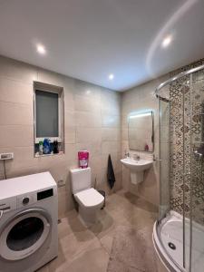 a bathroom with a toilet and a sink and a washing machine at Spacious Private Room with a shared bathroom -Shared Flat in St Julian's