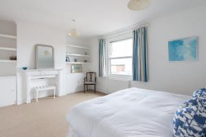Un dormitorio blanco con una cama y una ventana. en Beken House, en Cowes