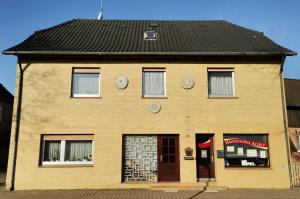 a yellow brick building with a black roof at Haus der Könige in Wietzendorf