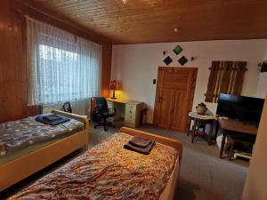 a bedroom with two beds and a desk and a television at Haus der Könige in Wietzendorf