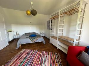 a bedroom with a bunk bed and a red chair at Maisons Les Gites de l'Odet in Clohars-Fouesnant +28 photos