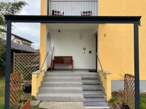 a set of stairs leading to a house with a bench at 4 Zimmer Wohnung, 6 Bed, Küche, Waschmaschine, Wlan, Garden, free Parking in Tacherting
