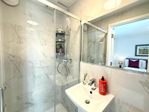 une salle de bain blanche avec lavabo et douche dans l'établissement Paradigm House, Luxury 2-Bedroom Apartment 3, Free Parking, Oxford, à Oxford