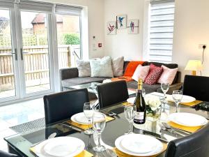 une salle à manger avec une table, des chaises et un canapé dans l'établissement Paradigm House, Luxury 2-Bedroom Apartment 3, Free Parking, Oxford, à Oxford