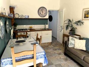 a kitchen with a table and a couch and a clock at Lavande in Lauzun