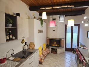 a kitchen with a living room with a fireplace at Il Riposo del Viaggiatore by Holiday World in Ternate