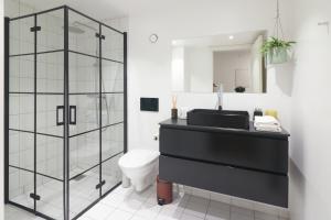 a bathroom with a black sink and a toilet at Designer 2 BR Home with Private Balcony in Copenhagen