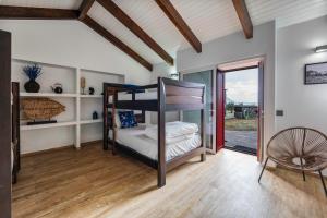 a room with a bunk bed and a chair at Kuanza Nature Experience, Fajã do Belo in Fajã da Caldeira de Santo Cristo