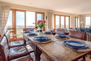 a wooden table with wine glasses and flowers on it at Fairhaven, Thorpeness in Thorpeness
