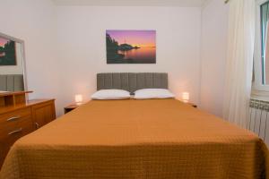 a bedroom with a bed with two candles on it at Apartment Kreso in Tkon