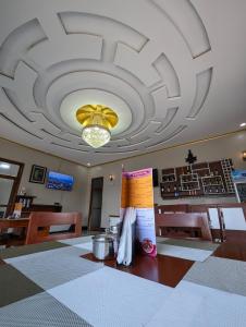 a dining room with a large ceiling and a table at Hotel Meyzieu in Dodoma