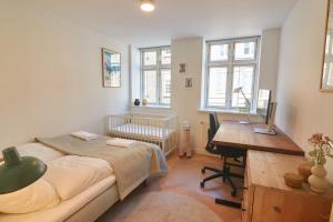 a bedroom with a bed and a desk and a crib at Designer 2 BR Home with Private Balcony in Copenhagen