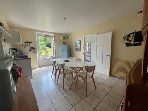 a kitchen with a table and chairs and a refrigerator at Maisons Les Gites de l'Odet in Clohars-Fouesnant