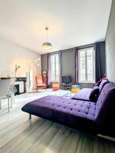 un grande letto viola in una stanza con pianoforte di Le Thiers - Hypercentre - Wifi - Air conditioning portable ad Avignone Altre 41 foto