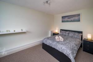 a bedroom with a bed and two night stands at Composers apartment in Cowes