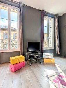 un soggiorno con TV a schermo piatto e 2 finestre di Le Thiers - Hypercentre - Wifi - Air conditioning portable ad Avignone