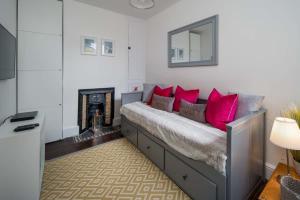 een kamer met een bed met rode kussens en een open haard bij Firefly House in Cowes +13 foto's