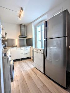 una cucina con un grande frigorifero in acciaio inossidabile di Le Thiers - Hypercentre - Wifi - Air conditioning portable ad Avignone