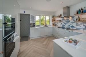 a large kitchen with white cabinets and a counter at Spring Hill, Colwell in Freshwater