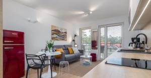 a kitchen and living room with a couch and a table at Prestige Red z basenem in Pobierowo