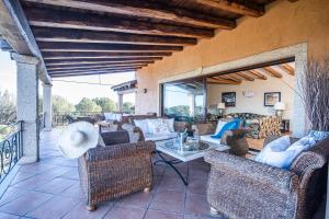 un patio con sillas de mimbre y una mesa en un patio en Villa Sul Golfo, en Cannigione