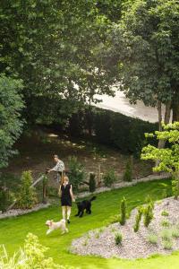 two people walking two dogs in a yard at Belia Lofts - ADULTS ONLY - Apartments in Appiano sulla Strada del Vino
