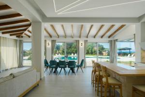 un soggiorno con un bar e sedie di Villa Aurora Blue with private pool - just tens of meters from the sea - by PosarelliVillas ad Acharavi