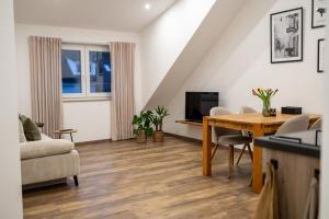 a living room with a table and a tv at Ferienwohnung Fränkische Auszeit in Wolframs-Eschenbach