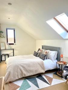 a bedroom with a large bed and a skylight at Priory Barn Apartment in Street +46 photos