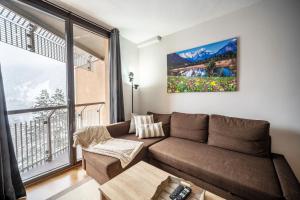 Una sala de estar con un sofá y una ventana grande. en Apartamento con Encanto Baqueira 1500, en Naut Aran (Alto Arán)
