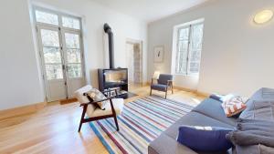 a living room with a couch and a tv at Le Moulin de la Cigogne in Saint-Vincent-Rive-dʼOlt