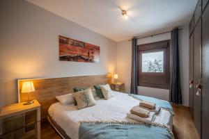 Un dormitorio con una cama con almohadas encima. en Apartamento con Encanto Baqueira 1500, en Naut Aran (Alto Arán)