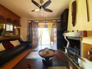 a living room with a ceiling fan and a fireplace at TH31 Casa adosada con piscina y playa al lado in Torredembarra