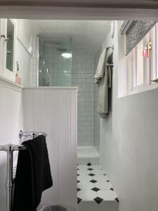 a bathroom with a shower and a black and white tile floor at Yew Tree House, Bed & Breakfast in Colchester in Lexden