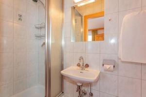 a white bathroom with a sink and a shower at Haus Traudi in Rauris +36 photos