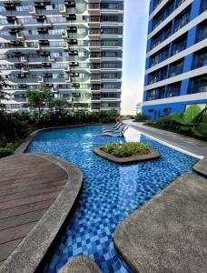 マニラにあるAir Residence T1 Amazing Makati Luxury Condo 66 sq m 300Mbps Fastの高層ビルの前のスイミングプール