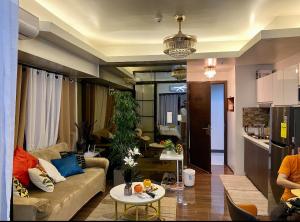 マニラにあるAir Residence T1 Amazing Makati Luxury Condo 66 sq m 300Mbps Fastのソファとテーブルのあるリビングルーム