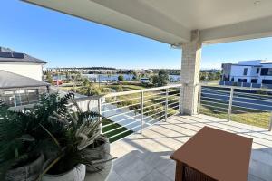 een balkon met een tafel en uitzicht op een haven bij Lotus Grand Home in Mango Hill Sleeps 8 in North Lakes