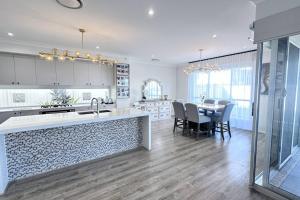 een keuken en eetkamer met een tafel en stoelen bij Lotus Grand Home in Mango Hill Sleeps 8 in North Lakes