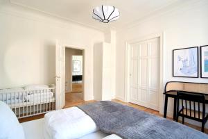 Un dormitorio blanco con una cama y un escritorio. en Huge modern & central 2BR loft, en Copenhague